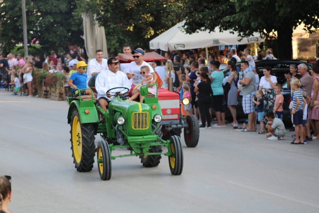 Stari traktor u žetvenoj povorci, uz posjetitelje uz cestu – Žetvene svečanosti u Cerni