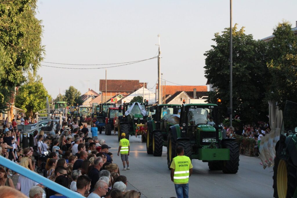 Kolona traktora u žetvenoj povorci kroz Cernu, uz okupljene posjetitelje